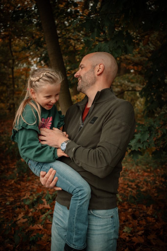 Warme knuffels van vader en dochter tijdens de herfstfotoshoot.